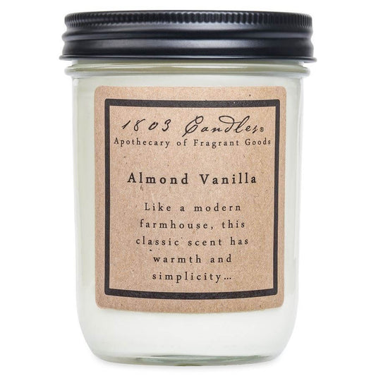White candle jar with a black lid and kraft paper label that reads Almond Vanilla