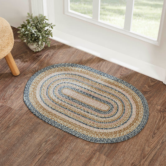 oval braided rug in blue, cream, light pink, and gold