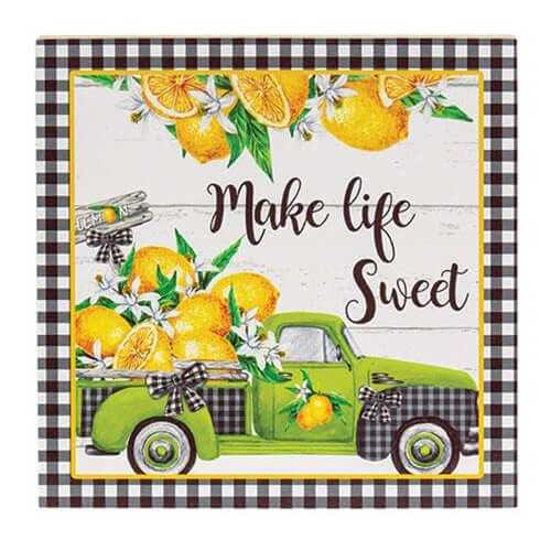decorated block with lemons in the back of a green pick up truck and a black and white check border.