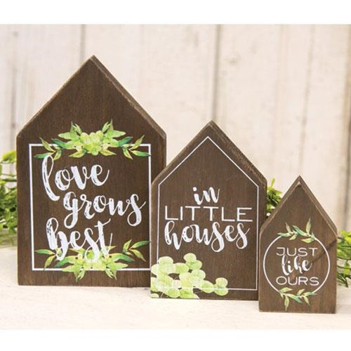 wood house block in 3 different sizes. Bigger one says love grows best, second says in little houses and the smallest says just like ours