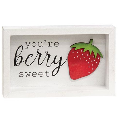 small white shadow box sign with a red strawberry with green stem, and lettering says you're berry sweet